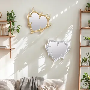 Dettaglio di specchi a forma di cuore con spine in oro e argento sulla parete soleggiata