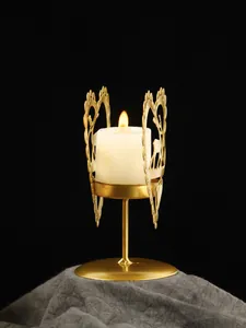 Vista detallada de la silueta de corazón y ciervo en un candelabro de hierro dorado