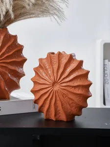 Detailed view of handmade modern seashell-shaped resin vase with terracotta texture