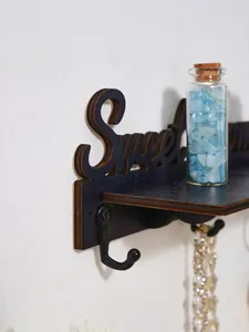 Detail van houten 'Sweet Home' sleutelrekje met wandhaken en decoratieve fles