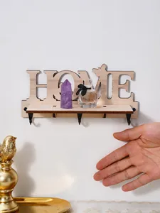 Primo piano del portachiavi in legno HOME con mano per riferimento alle dimensioni