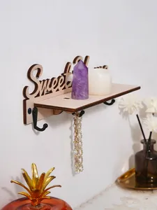 Detailweergave van houten Sweet Home wandplank met haken en woondecoratie-accessoires