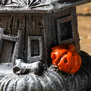 Nahaufnahme eines Halloween-Geisterhauses aus Harz mit einem kleinen Kürbisdetail.