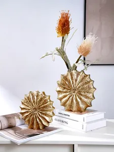 Detail of modern gold resin vases with seashell texture and elegant home decor styling