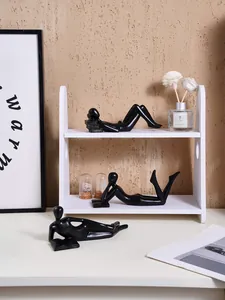 Minimalist black figurines in reading poses arranged on a white shelf for home decor