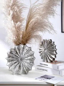 Detailed shot of modern silver shell-shaped resin vases with dried pampas grass decor