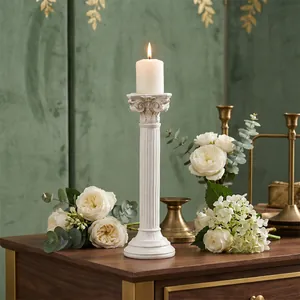 Elegante candelabro de resina blanca con forma de columna romana sobre mesa con rosas
