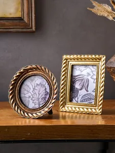 Detailansicht europäischer Vintage-Bilderrahmen mit goldenem Spiralrand und Blumenmuster.