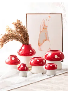 Group of cute red and white mushroom-shaped resin vases in various sizes.