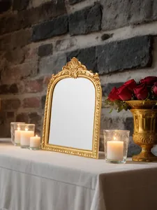 Makro-Detail eines verzierten goldenen Harzrahmens mit Barock-Schnitzereien bei Kerzenschein