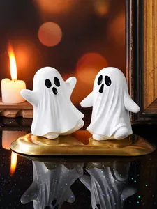 Deux figurines de fantômes en résine blanche dans un décor festif et effrayant d'Halloween