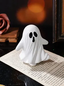 Détail macro d'une figurine de fantôme d'Halloween blanche sur du papier ancien.