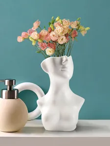 Kreative menschliche Büstenvase aus weißem Harz mit bunten Blumen im Wohnbereich