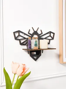 Bee-shaped black wooden wall shelf featuring small crystal bottles and a candle.