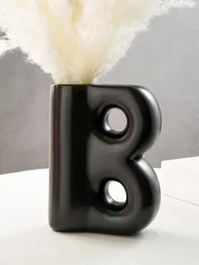 Vaso moderno in resina nero opaco a forma di B con decorazione in erba pampa
