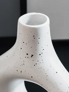 Gedetailleerde close-up van de matte textuur en zwarte spikkels op een witte Noorse vaas