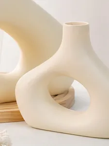 Detailopname van minimalistische witte hars vaas met matte afwerking en hol ovaal ontwerp