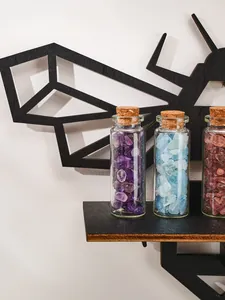 Close-up of black geometric bee wall shelf displaying colorful crystal jars.