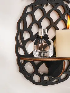Vue détaillée de l'étagère murale en bois noir en forme d'ananas avec des objets déco