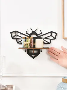 Detailed view of the black geometric bee-shaped wooden wall shelf with decorative items.