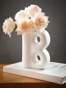 Primo piano di un moderno vaso in resina bianca a forma di B per decorazioni casa