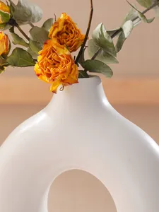 Detailweergave van de elegante curve en matte afwerking van de witte O-vormige vaas