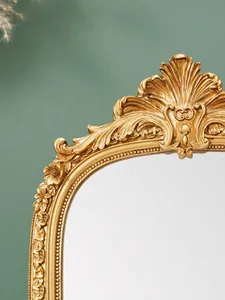 Detailaufnahme eines verzierten goldenen Harz-Spiegelrahmens mit Barock-Schnitzereien