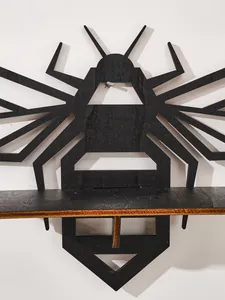 Close-up of black bee-shaped wooden wall shelf with detailed wood grain texture