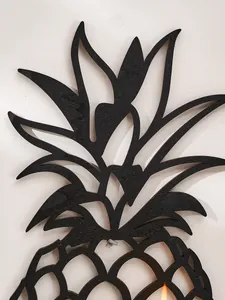Gros plan d'une étagère murale en bois noir en forme d'ananas au design évidé