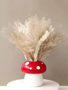 Detailed view of creative red and white mushroom-shaped resin flower vase with pampas grass