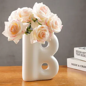Moderno vaso in resina bianca a forma di B con rose rosa artificiali per decorazione