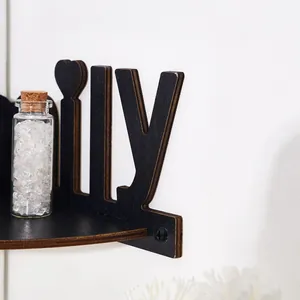 Detailed macro shot of black wood family letter wall shelf with decorative glass bottle