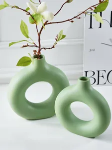 Detail van twee groene Noorse O-vormige keramische vazen met minimalistisch design