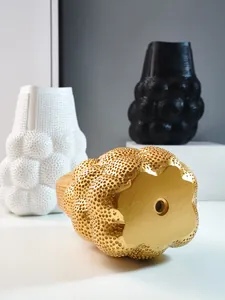 Nahaufnahme des einzigartigen Lochmusters auf einer modernen goldenen Vase aus ABS-Harz