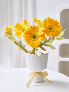 Detailed view of a unique hand-shaped white resin flower vase with yellow daisies
