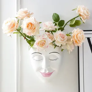 Minimalist white resin human face wall-mounted flower pot with pink roses