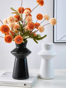 Close-up of modern black and white lighthouse-shaped resin vases for stylish home decor