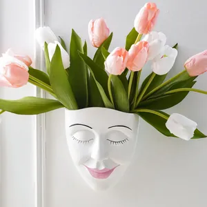 Minimalist face-shaped resin wall planter with pink tulips for elegant indoor home decor