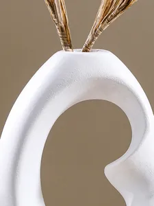Close-up detail of white textured resin vase showing abstract spiral curves and stems