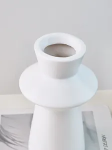 Close-up of minimalist white lighthouse-shaped resin vase showing smooth texture and modern design