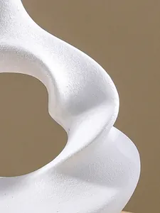 Macro detail showing the white sand-textured surface of a modern abstract spiral resin vase.