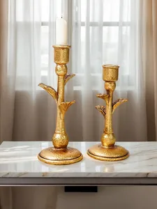 Detail view of vintage gold coconut tree candle holders on a white marble table top