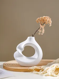 Elegant modern abstract white resin vase with spiral design on a wooden display tray.