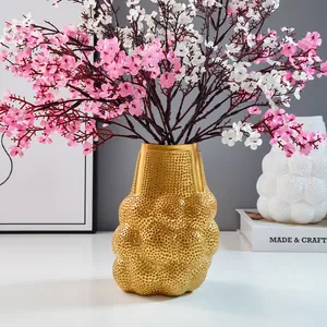 Moderne goldene Harzvase mit Netzstruktur für elegante Blumendekoration zu Hause