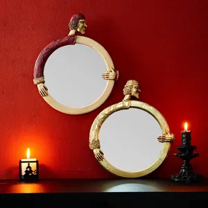 Due specchi rotondi decorativi in resina stile re europeo su parete rossa candele