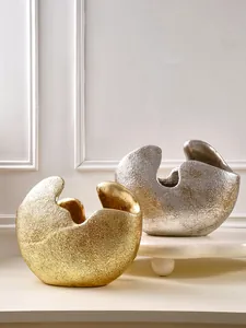Detailweergave van abstracte halfronde harsvazen in goud en zilver voor modern interieur.