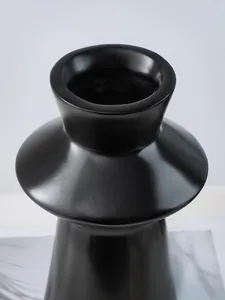 Close-up detail of modern minimalist black lighthouse-shaped resin decorative vase