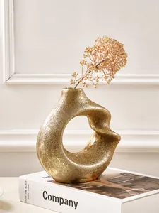 Close-up of a modern Nordic gold spiral resin vase with an abstract artistic design