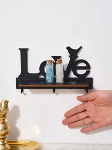 Macro detail of decorative black wooden LOVE wall shelf featuring hooks and bird accent