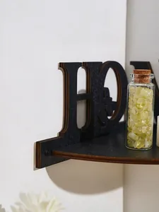 Close-up detail of black wooden HOME letter corner shelf with a natural matte finish.